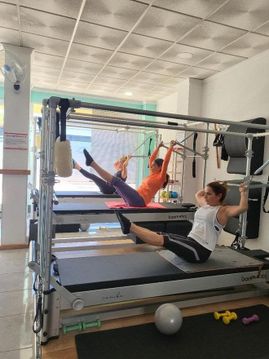 Mujeres estirando en cama de pilates