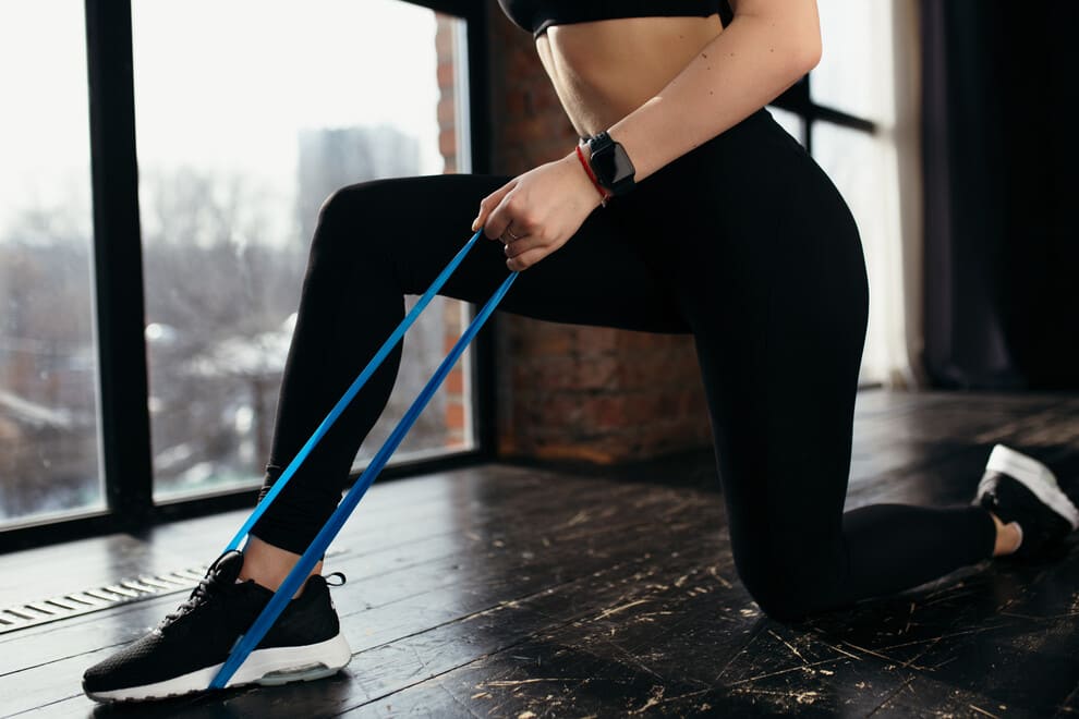 mujer haciendo pilates con cinta elástica