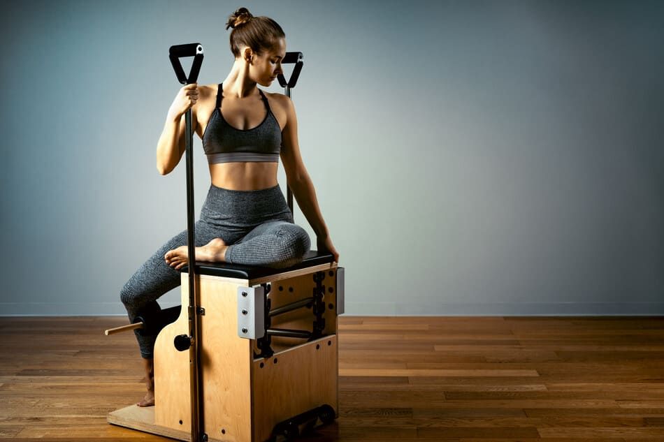 mujer sentada en máquina de pilates