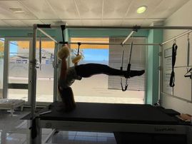 Monitora de pilates entrenando en máquina