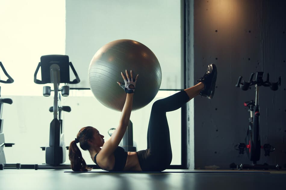 mujer haciendo pilates con pelota fit